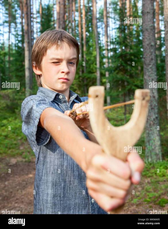 boy-aiming-wooden-slingshot-outdoors-WKMA95.jpg